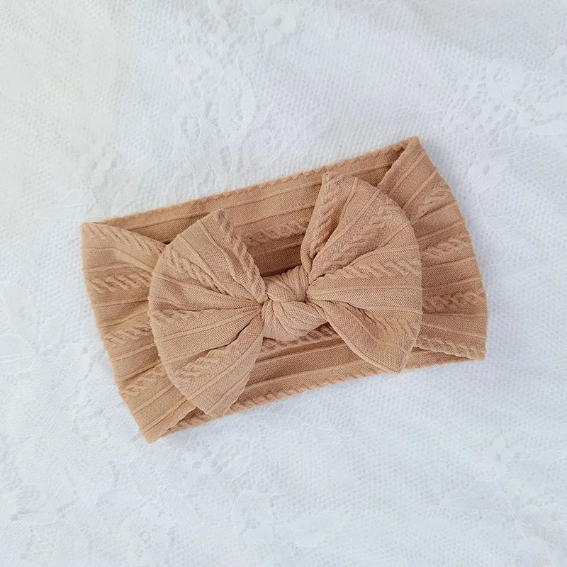 Beige headband with a bow on a white background